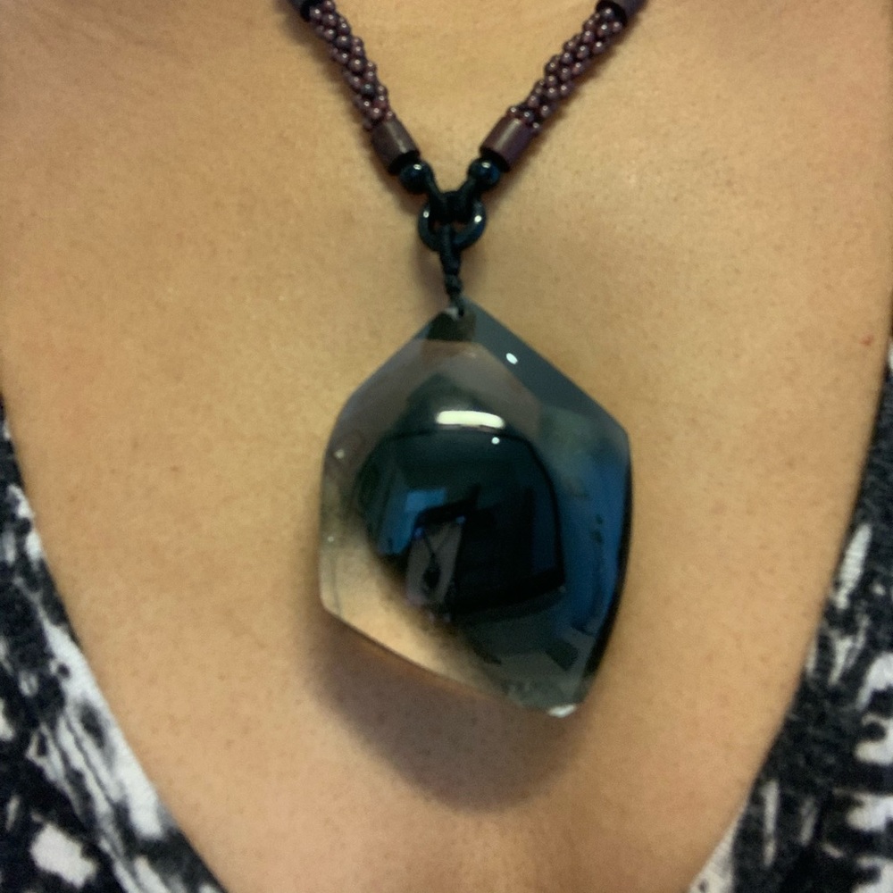 Black oblong stone with beaded necklace